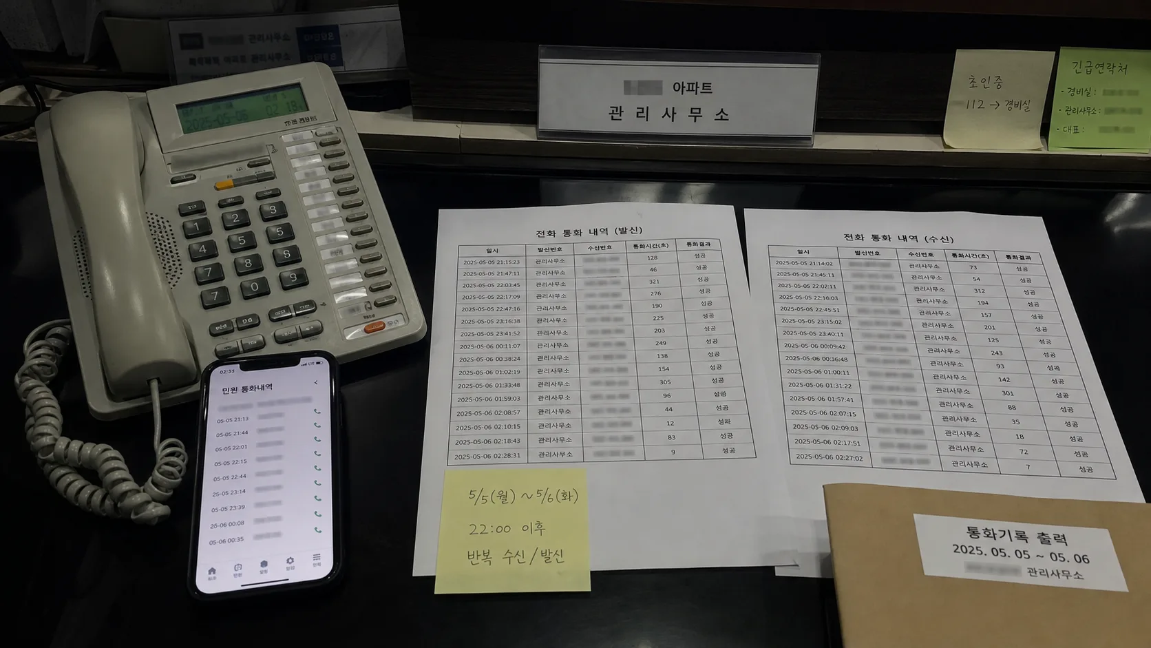관리사무소 책상 위 전화기와 통화 기록 출력물, 생활지원 앱 화면